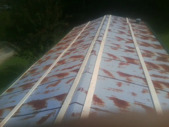 Rusted metal roof panels with new wood purlins before replacement — Storm Damage Roof Repair in Hordville by Roofing Brothers