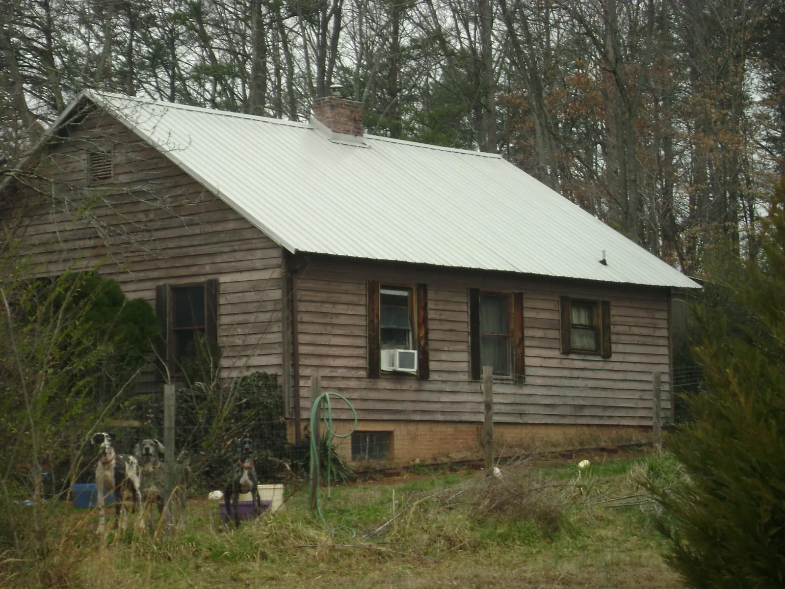 White metal roof on an old wood sided farmhouse, from a Metal Roof Installation job in Hordville
